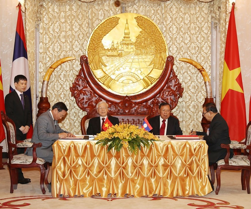 El secretario general del Partido Comunista y presidente de Vietnam, Nguyen Phu Trong, y el secretario general del Partido Popular Revolucionario y presidente de Laos, Bounnhang Vorachith, asistieron a la firma del acuerdo de cooperación bilateral en la construcción del Centro de Servicio Técnico Agrícola de la provincia laosiana de Houaphan. (Fuente: VNA) 