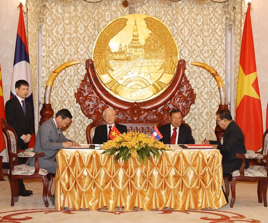 El secretario general del Partido Comunista y presidente de Vietnam, Nguyen Phu Trong, y el secretario general del Partido Popular Revolucionario y presidente de Laos, Bounnhang Vorachith, asistieron a la firma del acuerdo de cooperación bilateral en la construcción del Centro de Servicio Técnico Agrícola de la provincia laosiana de Houaphan. (Fuente: VNA) 