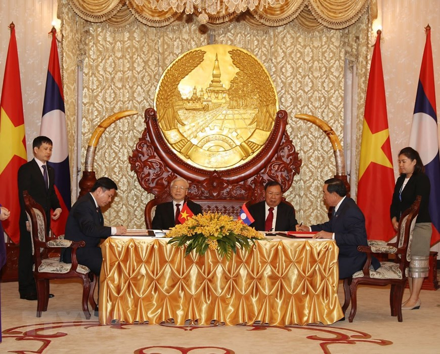 El secretario general del Partido Comunista y presidente de Vietnam, Nguyen Phu Trong, y el secretario general del Partido Popular Revolucionario y presidente de Laos, Bounnhang Vorachith, asistieron a la firma del acuerdo de cooperación bilateral en la construcción de la línea ferroviaria que enlace a la capital de Vientiane con el puerto Vung Ang, en la provincia centrovietnamita de Ha Tinh. (Fuente: VNA) 