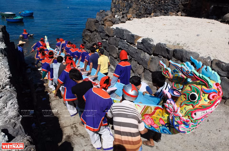Remeros en la aldea de Tay, la comuna de An Vinh, bajan el bote al agua (Foto: VNA)