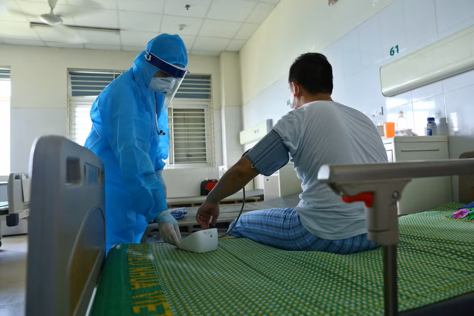 Médicos chequean la salud de los pacientes de COVID-19 que están siendo tratados en el Hospital Central de Enfermedades Tropicales 2, en el distrito de Dong Anh, en Hanoi. (Foto: VNA)