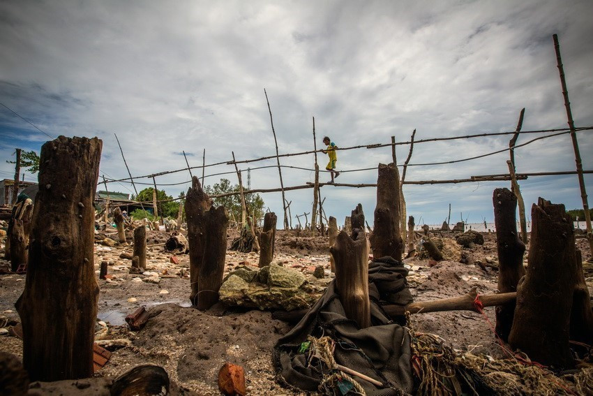 Debido a la grave intrusión de agua de mar, los habitantes de la aldea de Kenh Dao Dong, comuna de Dat Mui, distrito de Ngoc Hien, en la provincia sureña de Ca Mau, tienen que pasar por precarios puentes durante la marea alta ( Foto: VNA)