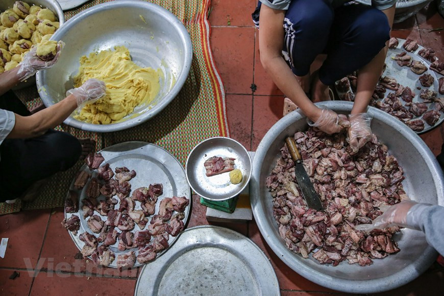 Cerca de Tet, unos 120 hogares en la aldea de Tranh Khuc están ocupados envolviendo Banh chung. Un gran hogar productor puede elaborar hasta miles de pasteles al día. La familia de señora Sau en la aldea de Tranh Khuc se ha dedicado a hacer Banh chung durante décadas. Según ella, solo elabora de 200 a 300 pasteles diarios, pero a partir de diciembre, la cantidad de pasteles se multiplica de dos a tres veces. Banh chung de la aldea Tranh Khuc es delicioso gracias a sus ingredientes cuidadosamente seleccionados. Se usa el arroz glutinoso “nep cai hoa vang”, uno de los mejores, para que la corteza sea suave. Las judías verdes deben ser semillas pequeñas, frescas y de color amarillento (Foto: Vietnamplus)