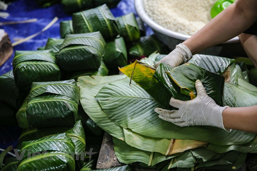 Los Banh chung más delicados se colocaban en el altar de los ancestros, mientras los pasteles pequeños se regalaban a los niños, como un obsequio del Tet. En la vida moderna, esta costumbre se ha perdido poco a poco. En las ciudades, muy pocas familias mantienen la tradición de elaborar el Banh Chung, y la mayoría los compra en las tiendas. El método para prepararlo también ha cambiado: la olla de hierro fue sustituida por la de presión para ahorrar el tiempo, y casi nunca se ve el fuego de leña. Ante esa situación, numerosas personas se han esforzado para conservar esta tradición del pueblo. En diversos lugares, se estimulan a los pobladores a mantener la costumbre antigua, y se organizan concursos para elaborar el Banh Chung (Foto: Vietnamplus)