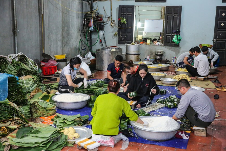 Cada vez que llegan los últimos días del calendario lunar, los vietnamitas alejados de su tierra natal quieren finalizar lo más pronto posible su trabajo para reunirse con su familia y empezar los preparativos del Tet, particularmente la elaboración del Banh chung. En el pasado, las familias solían preparar los ingredientes del Banh chung con dos o tres días de antelación, para que todos los miembros pudieran elaborar los pasteles, de manera conjunta, durante el último día del calendario lunar. Para muchas generaciones, el momento más divertido del Tet era cuando la familia se congregaba alrededor de una gran olla de hierro, colocada por encima del fuego de leña, y esperaba para que los Banh chung se cocinaran por dentro (Foto: Vietnamplus)