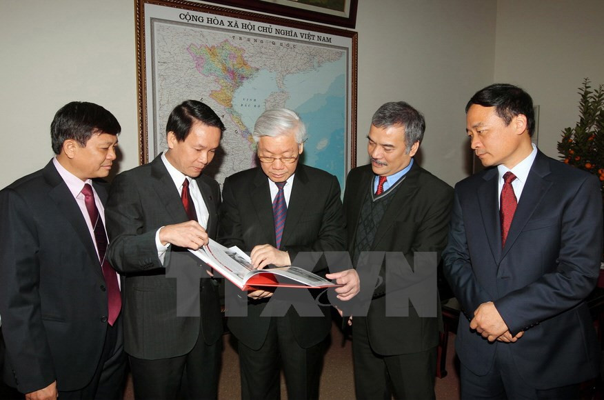 El secretario general del Partido Comunista de Vietnam, Nguyen Phu Trong (C) y dirigentes de la agencia leyeron nuevas publicaciones de la VNA 