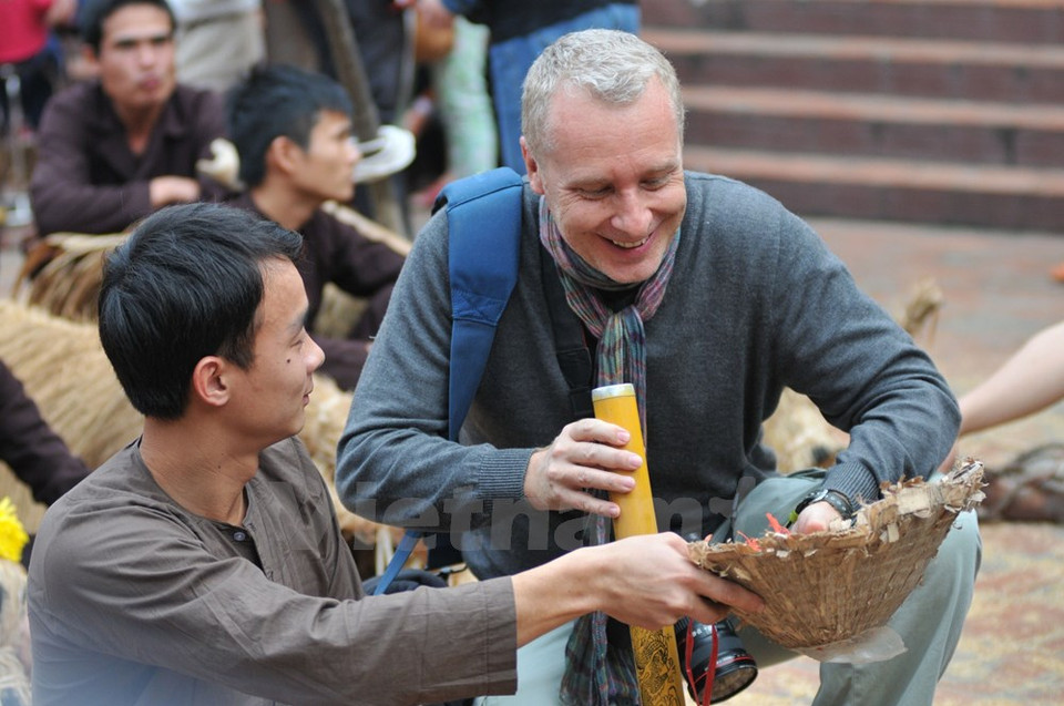 Turista extranjero interesado en la pipa y el Non La (sombrero cónico) (Fuente: VNA)