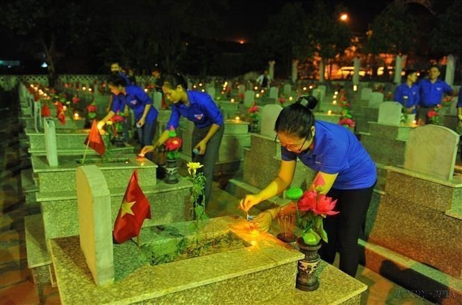 Miembros sindicales y jóvenes del distrito de Yen Mo encienden velas para rendir homenaje a los héroes y mártires en el Cementerio dedicado a Mártires en el distrito de Yen Mo, provincia de Ninh Binh. (Fuente:VNA)