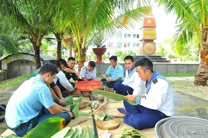 La alegría de los jóvenes soldados al envolver banh chung (pastel cuadrado de arroz glutinoso) con sus propias manos para dar la bienvenida al Tet (Nuevo Año Lunar) y la primavera a la isla de Phan Vinh, distrito insular de Truong Sa, provincia de Khanh Hoa. (Fuente:VNA)