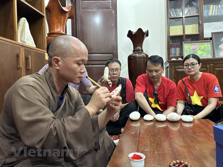 El venerable Thich Nhuan Dat, abad de la Pagoda de Truong Sa Lon, entrega letras a las personas que visitan Truong Sa. (Foto: VNA)