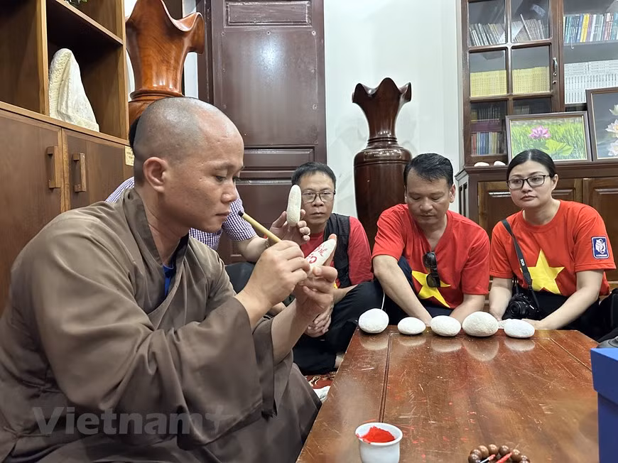 El venerable Thich Nhuan Dat, abad de la Pagoda de Truong Sa Lon, entrega letras a las personas que visitan Truong Sa. (Foto: VNA)