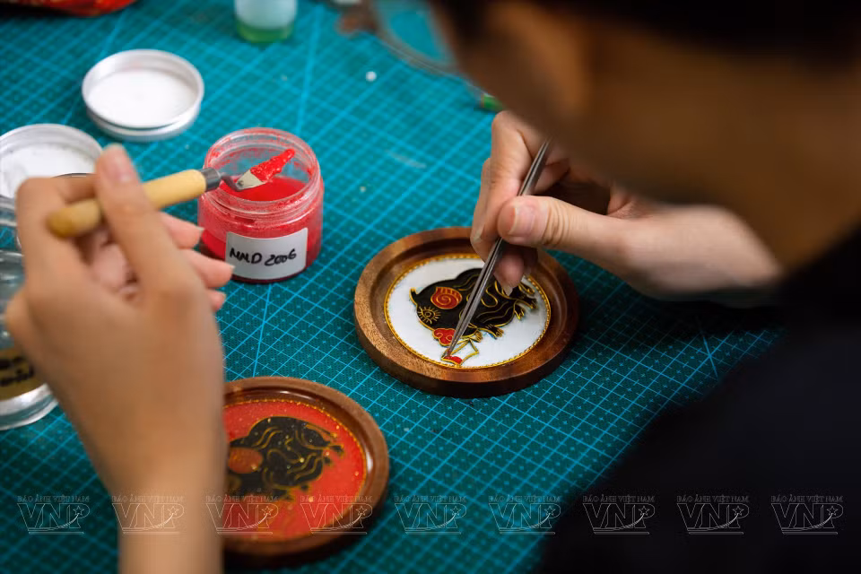 Después de terminar de colocar el alambre de cobre para tener un marco de patrón específico, el trabajador comienza a mezclar arenas en diferentes colores. (Fuente: Revista Ilustrada Vietnam)