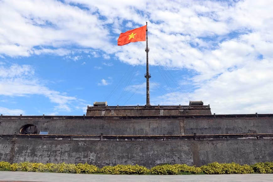 Bandera roja con la estrella amarilla ondeando sobre el asta en la plaza Ngo Mon (Foto: VNA)