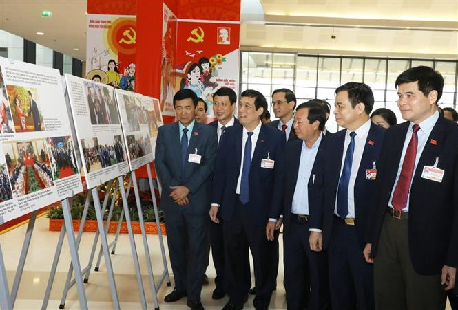 Los delegados visitan la exhibición fotográfica ¨Avanzar con paso firme bajo la bandera del Partido glorioso¨, organizada por la Agencia vietnamita de Noticias al servicio del XIII Congreso del Partido Comunista de Vietnam (Fuente: VNA)