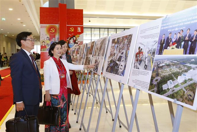 Los delegados visitan la exhibición fotográfica ¨Avanzar con paso firme bajo la bandera del Partido glorioso¨, organizada por la Agencia vietnamita de Noticias al servicio del XIII Congreso del Partido Comunista de Vietnam (Fuente: VNA)