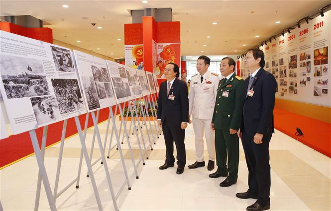 Los delegados visitan la exhibición fotográfica ¨Avanzar con paso firme bajo la bandera del Partido glorioso¨, organizada por la Agencia vietnamita de Noticias al servicio del XIII Congreso del Partido Comunista de Vietnam (Fuente: VNA)