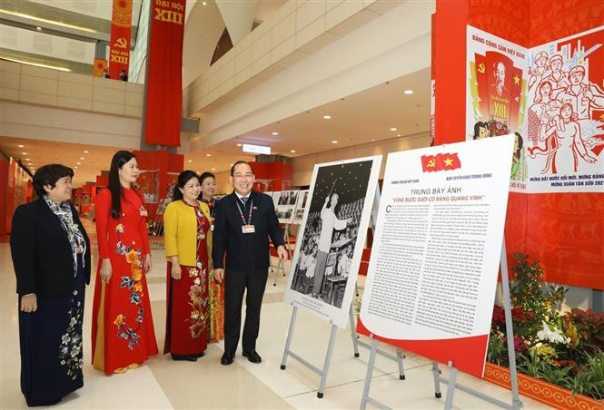 Los delegados visitan la exhibición fotográfica ¨Avanzar con paso firme bajo la bandera del Partido glorioso¨, organizada por la Agencia vietnamita de Noticias al servicio del XIII Congreso del Partido Comunista de Vietnam (Fuente: VNA)