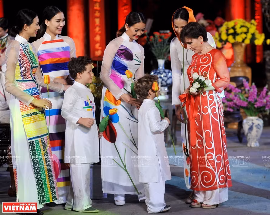 La embajadora de Italia en Vietnam, Cecilia Piccioni (camisa roja) porta el Ao Dai de la colección de flores de tulipán de la marca de moda Chula, durante una visita al Templo de la Literatura (Van Mieu-Quoc Tu Giam), en Hanoi. (Fuente: Revista Ilustrada de Vietnam)