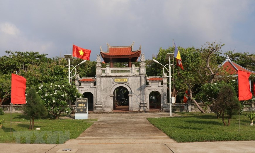 Frente a la puerta de la Pagoda Truong Sa, en la ciudad de Truong Sa (del distrito homónimo en la provincia central de Khanh Hoa), la bandera nacional es izada en una posición solemne. (Foto: VNA)