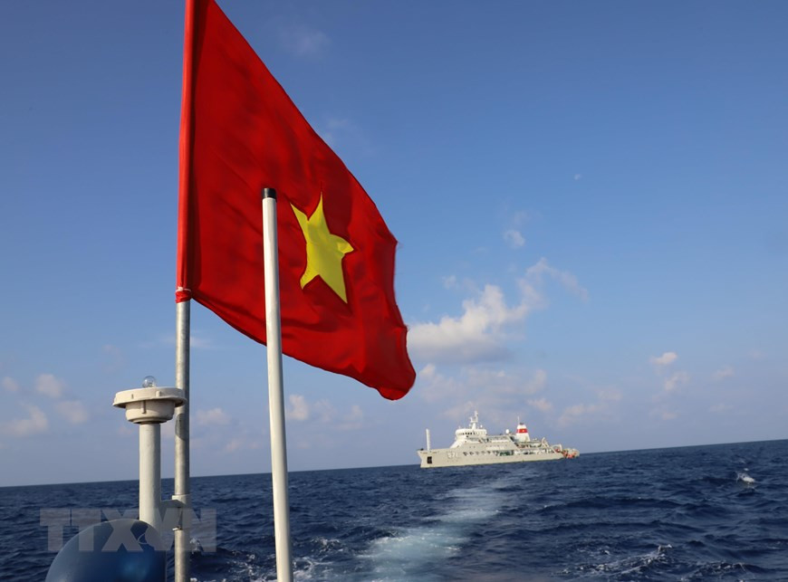 La bandera nacional ondea en el techo de una lancha que transporta a oficiales y soldados desde el barco Truong Sa 571 a la isla Song Tu Tay (Foto: VNA)