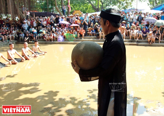 Un anciano de la aldea lleva el balón de unos 20 kilogramos al campo.