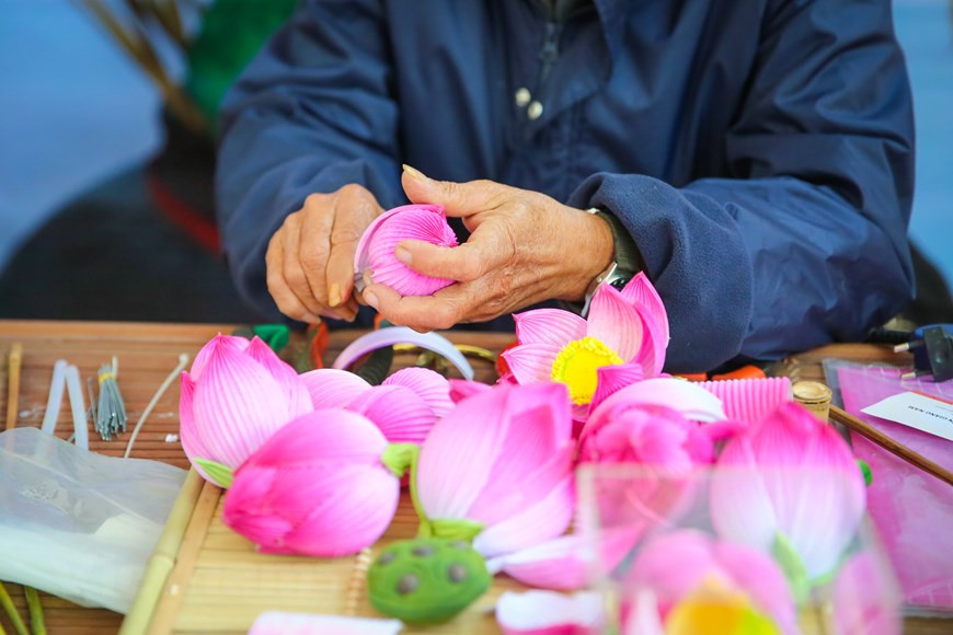 Para satisfacer las necesidades del mercado de flores en ocasión del Tet, los artesanos aquí se ocupan de asegurar la cantidad de productos. Hacer una flor requiere que los artesanos tengan manos hábiles y meticulosas, las etapas para fabricar una incluyen varias etapas: el bambú se corta y se seca; el papel se colorea; las flores se recortan meticulosamente para que cuando se retire el pegamento, se cree una rama de flor que esté en armonía con el color y el diseño. Un artesano de flores de papel experto puede hacer de 15 a 20 flores por día, por lo que tiene que realizar máximos esfuerzos para satisfacer la demanda del mercado. (Foto: Vietnam+)