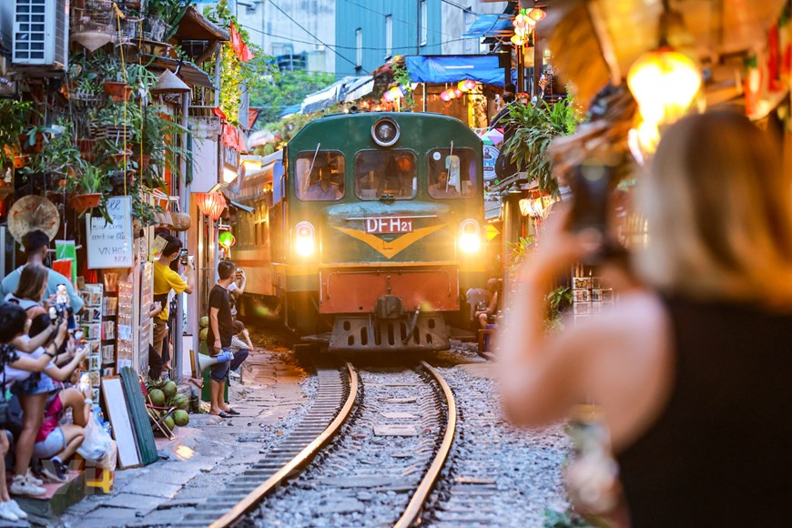 Tras aparecer por primera vez en el diario británico DailyMail en abril de 2014, la calle del tren se ha convertido en un destino atractivo para los turistas en Hanoi. A propósito del creciente número de visitantes, a lo largo de la vía comenzaron a "brotar" muchos cafés. En TripAdvisor, el sitio ocupa actualmente el segundo lugar entre 107 destinos pintorescos en Hanoi. Los visitantes acuden a la vía, tanto de día como de noche, para capturar el momento en que los trenes pasan. Ante el arribo de un tren, los puestos de guardia alertan con 10 minutos de anticipación, para cuidar la seguridad en la vía ferroviaria. (Foto: Vietnam+)