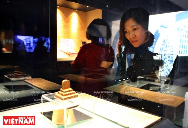 Visitante admira "Mon ha sanh an" (sello de oficina administrativa) es un sello de bronce con contenidos claros y una era específica relacionada con la historia de la administración central de la dinastía Tran. El sello fue lanzado durante la dinastía Tran, en el quinto año de Long Khanh (1377). Fue descubierto en 1962 en la comuna de HuongGiang (distrito de HuongKhe, provincia de Ha Tinh). Foto: Cong Dat / VNP