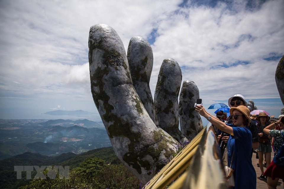 Los visitantes admiran magnífico escenario natural al estar de pie en el Puente Vang. (Fuente: VNA)