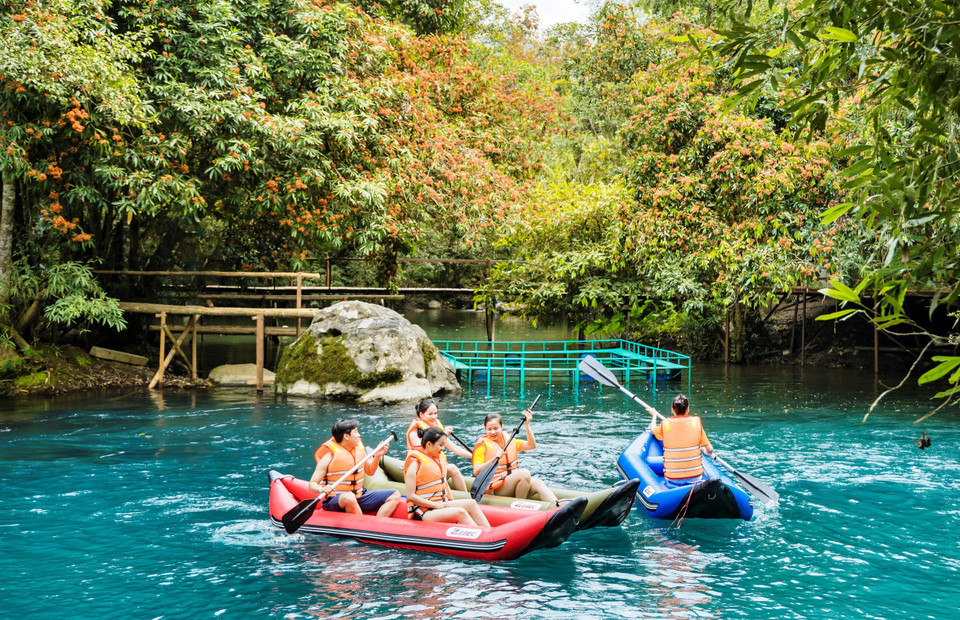 Los visitantes experimentan, exploran y disfrutan del hermoso paisaje y el clima fresco en el destino turístico del arroyo Mooc durante la temporada de floración del ashoka (Foto: VNA)