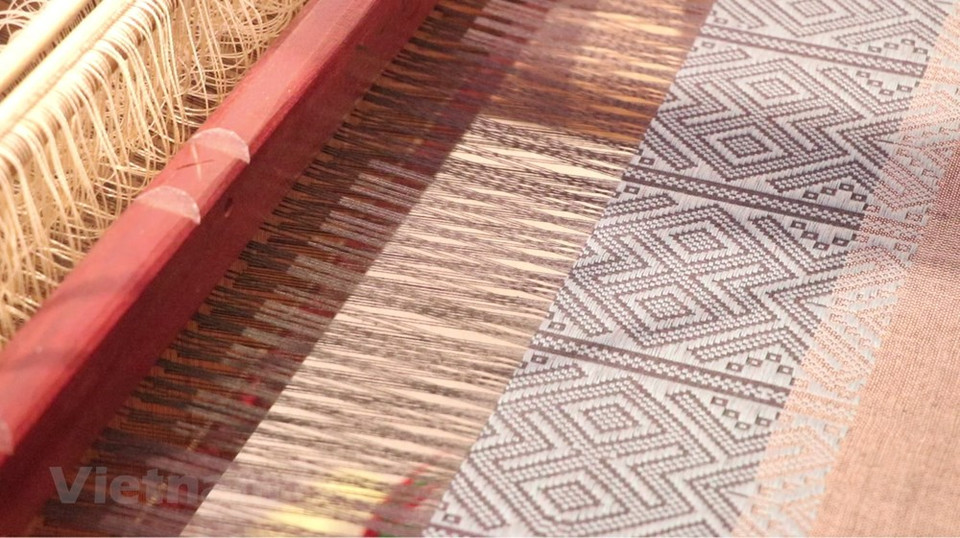 Ha Thi Tam, una mujer de la etnia Thai, de la comuna de Thanh Lam, del distrito de Ba Thuoc, con considerable experiencia en el tejido tradicional de brocados, se esfuerza por preservar la artesanía. Thi Tam usa brocado para confeccionar vestidos, camisas, almohadas, tapetes y cortinas. Sus productos se han vuelto populares en muchos albergues familiares y entre los turistas, gracias a los llamativos diseños. La gama de rubros de brocado del distrito de Ba Thuoc se amplió tanto en número como en diseños, y encontró el favor de muchos sitios turísticos comunitarios como la Reserva Natural de Pu Luong. Con 81 hogares que mantienen el tejido de brocado tradicional, Bac Thuoc fue reconocido como un pueblo artesanal tradicional. El tejido de brocados genera más de 200 dólares mensuales para cada artesano local (Fuente: Vietnam+)