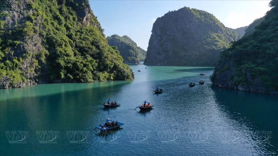 Los turistas viajan en barco para visitar y explorar las cuevas en la Bahía de Lan Ha. (Foto: VNA)