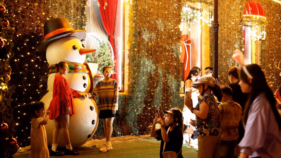 Diversas personas se toman fotos en el espacio navideño del edificio Diamond Plaza, Ciudad Ho Chi Minh. (Foto: VNA)