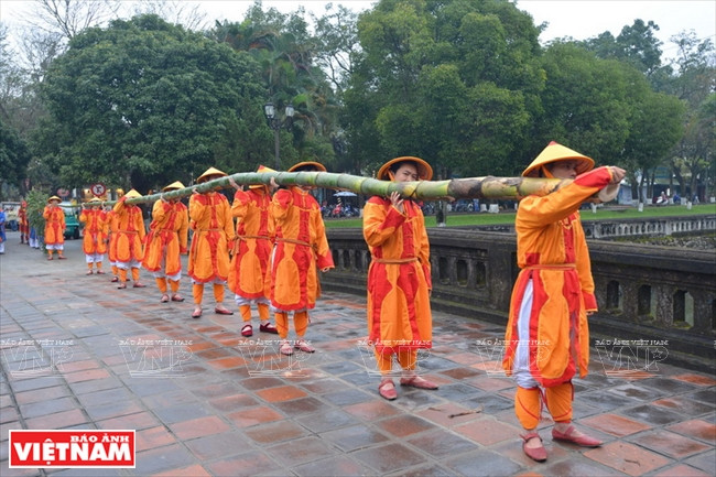 Diez hombres que actúan como guardias imperiales llevan el “Cay Neu”, que es un largo árbol de bambú con ramas y hojas. Foto: Thanh Hoa / VNP