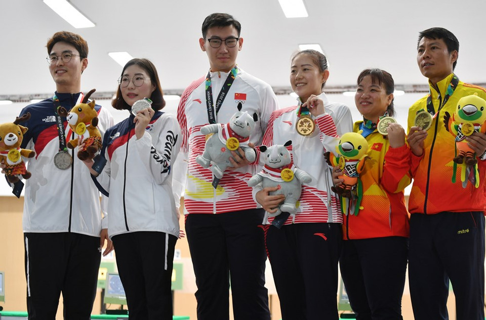  Le Thi Linh Chi y Tran Quoc Cuong ( los dos primeros por la derecha) ganan bronce en 10 metros de pistola 