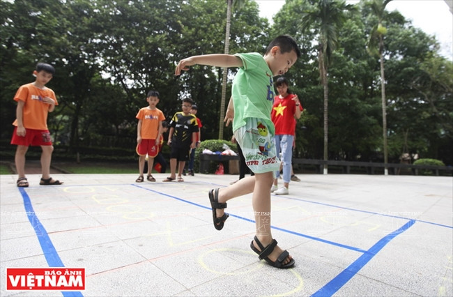 Juego salto a la pata coja (Foto: VNA)