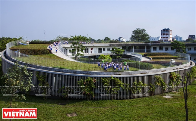 El techo curvado de la escuela va bajando hasta tocar el suelo.