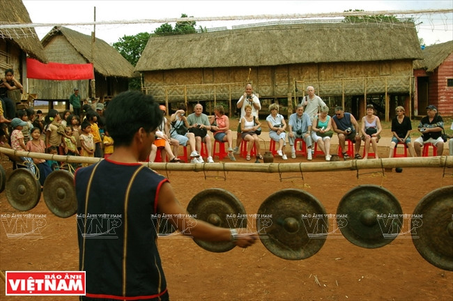 Disfrutándose de las melodías de los gongs de Tay Nguyen en una aldea cultural turística en la provincia de Gia Rai.