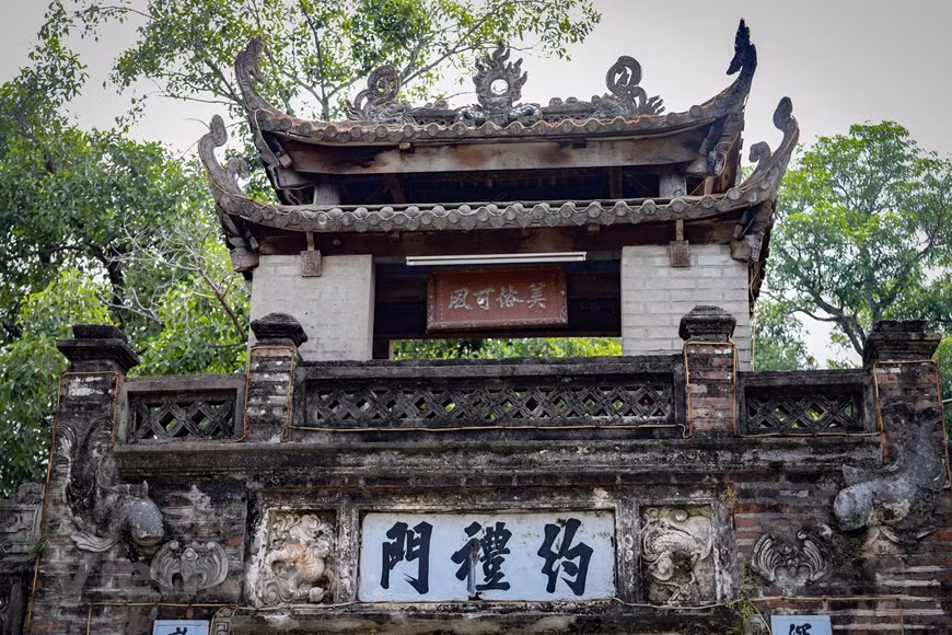 En la comuna de Tan Uoc, distrito de Thanh Oai, en Hanoi, aparece Uoc Le, una antigua aldea vietnamita. El pueblo es popular por su oficio tradicional de elaboración de Gio Lua (un plato vietnamita conocido también como embutido o salchicha) y la vetusta puerta principal, que se construyó durante la dinastía Mac y deviene una de las puertas conservadas más antiguas del oeste de la capital. La obra está situada a la entrada del pueblo, ocupando un gran espacio con puente, arcadas y grandes muros de ladrillo. La puerta tiene un letrero colgante que dice: "My Tuc Kha Phong" ("Se otorgan buenas costumbres"). (Foto: Vietnam+)