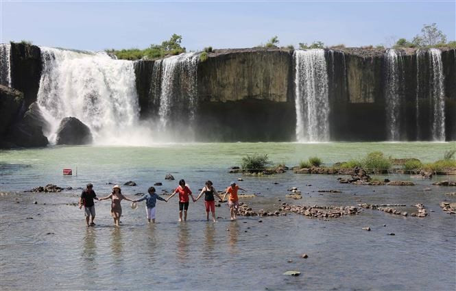 Los visitantes toman fotos frente a la cascada Dray Nur (Fuente: VNA)