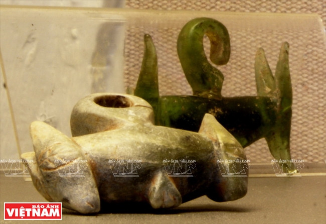 Pendientes de oreja hecho de piedra y cristal con antigüedad de dos mil 500 años. En dos puntos extremos se encuentran figuras animales ornamentales. 