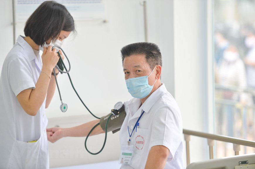 Un centenar de médicos y trabajadores del Hospital Central de Enfermedades Tropicales de Hanoi recibieron sus primeras inyecciones contra el COVID-19. A diferencia de las anteriores campañas de vacunación, las autoridades realizarán exámenes preparatorios a los receptores antes de la inyección, hecho que contribuirá a asegurar el éxito de la actividad, aunque costará más tiempo. A las personas vacunadas contra el COVID-19 se les recomienda permanecer al menos 30 minutos en observación en la sala de espera para detectar posibles reacciones adversas inmediatas. Se debe monitorear de cerca su estado de salud durante las siguientes 24 horas en casa y hasta tres semanas después de la inyección. Los hospitales se preparan para prevenir cualquier reacción grave posvacunación y garantizar la máxima seguridad para esas personas. (Foto: Vietnam+)