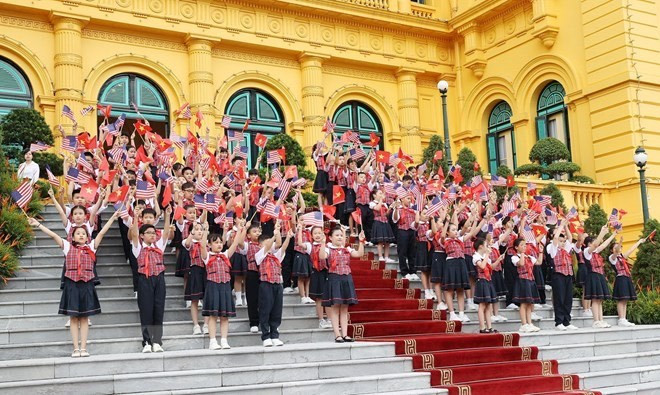 Niños de Hanoi ondean banderas de Vietnam y Estados Unidos para saludar al presidente estadounidense, Joe Biden, durante la ceremonia de bienvenida celebrada en su honor en Hanoi. (Foto: VNA)