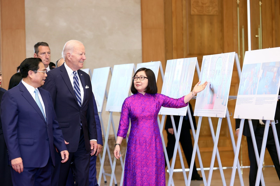 La subdirectora general de la VNA, Doan Thi Tuyet Nhung, presenta la exposición fotográfica al primer ministro Pham Minh Chinh y el presidente Joe Biden. (Foto: VNA)