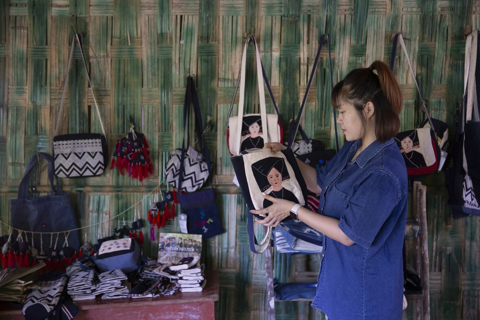 Los turistas compran productos de brocado de la etnia Dao Tien en la aldea Sung de la comuna de Cao Son, distrito de Da Bac, Hoa Binh. (Foto: VNA)