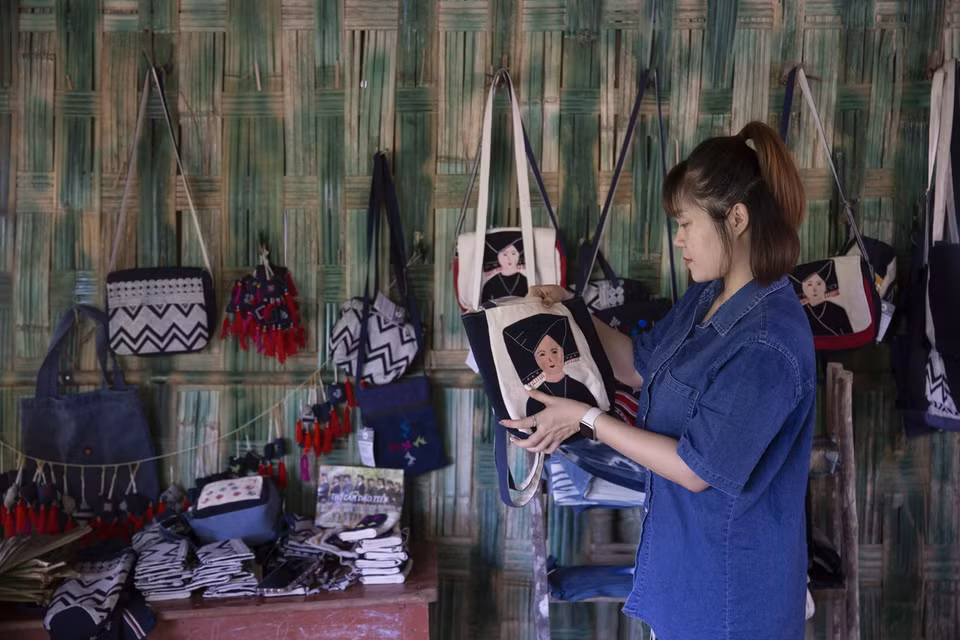 Los turistas compran productos de brocado de la etnia Dao Tien en la aldea Sung de la comuna de Cao Son, distrito de Da Bac, Hoa Binh. (Foto: VNA)