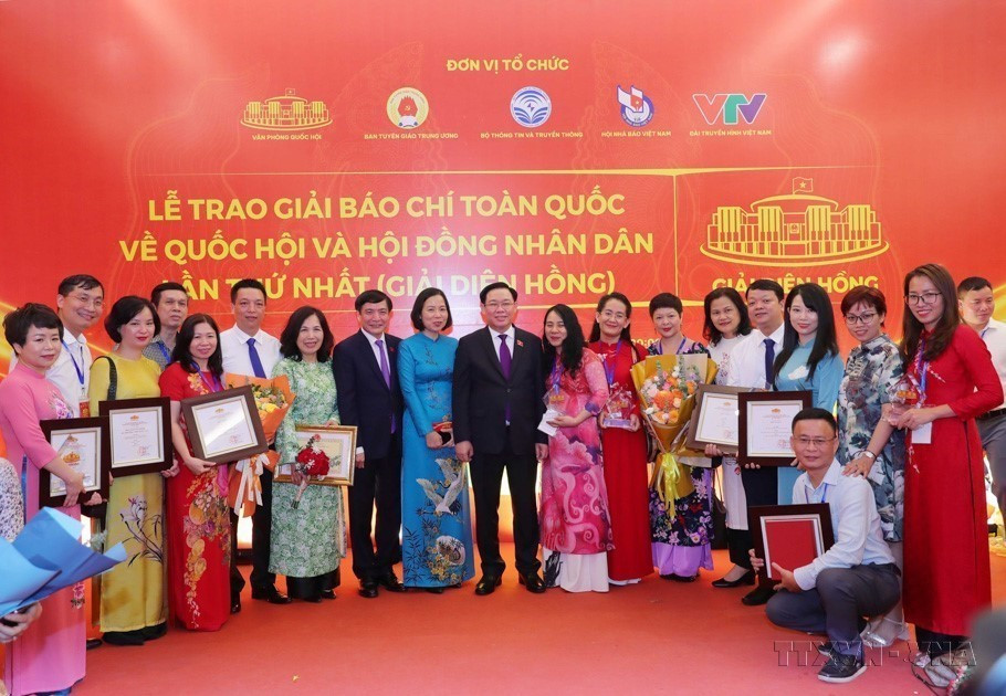 El presidente de la Asamblea Nacional, Vuong Dinh Hue, y la directors general, Vu Viet Trang, se fotografían con los autores y grupos de autores de la VNA que ganaron premios Dien Hong. (Foto: VNA)