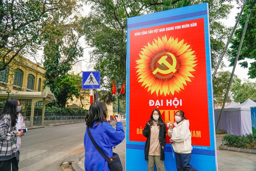 Los jóvenes toman fotos de recuerdo con un gran cartel de bienvenida al XIII Congreso Nacional del Partido Comunista de Vietnam. El cónclave contará con la participación de mil 587 delegados, que representan a más de cinco millones de militantes. Se trata del evento político más importante de la nación este año, al marcar un nuevo hito en el desarrollo del Partido y del país, e identificar las orientaciones estratégicas para impulsar la renovación e integración global de la nación. En los documentos del XIII Congreso Nacional se evalúan la implementación durante los últimos 35 años del proceso de Doi Moi (Renovación), los 30 años del despliegue del Programa Político sobre la construcción nacional en el período de transición hacia el socialismo y la materialización de la Estrategia de desarrollo socioeconómico en el plazo 2011-2020. (Foto: Vietnam+)