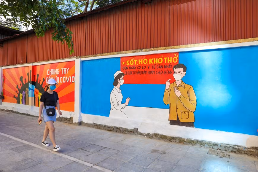 La obra cuenta con cerca de 100 metros de longitud y 10 imágenes de propaganda a gran escala sobre las medidas de prevención y control contra el COVID-19 (Foto: VNA)