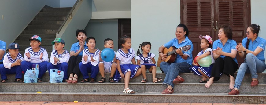 Alumnos de la escuela primara del pueblo Truong Sa cantan con los funcionarios que visitan la isla (Foto: VNA)